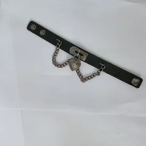 Draufsicht auf schwarzes Punk-Lederarmband mit Herzschloss und Ketten-Detail