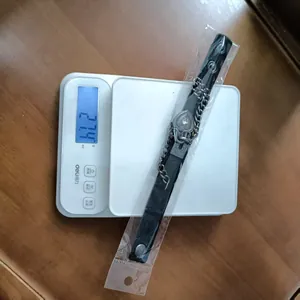 Nahaufnahme eines Punk-Lederarmbands mit Herzanhänger auf einer Waage, Gewicht 21,4 g.