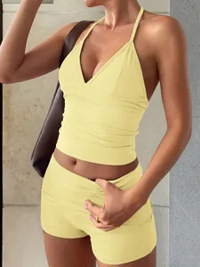 Vue détaillée de l'ensemble de yoga jaune à licou montrant la coupe ajustée et le tissu