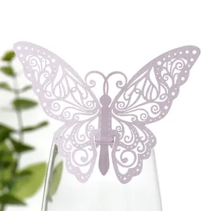 Décoration papillon 3D ajourée lavande élégamment placée sur le bord d'un verre