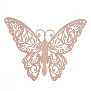 Détail d'un marque-place papillon en métal rose doré ajouré pour décoration de mariage