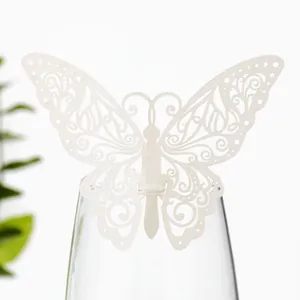 Vue détaillée d'un papillon en papier découpé au laser blanc utilisé comme décoration sur un verre