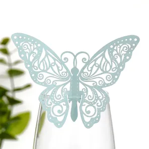 Gros plan détaillé d'une carte papillon bleu pailleté ajouré sur un verre