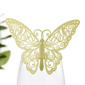 Vue détaillée d'un marque-place papillon doré découpé au laser sur le bord d'un verre
