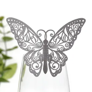Gros plan d'une carte papillon creuse grise utilisée comme marque-place décoratif de mariage