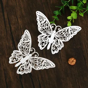 Vue détaillée des motifs complexes de décorations de papillons en papier blanc découpés au laser