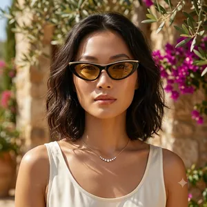 Stylish vintage cat-eye sunglasses with tea lenses, worn by a model in a sunny garden setting.
