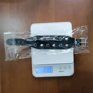 Macro detail of a punk rock leather bracelet with silver studs weighing 23.9g on a digital scale