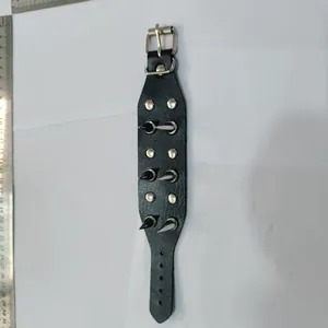 Macro view of black punk rock leather wristband with sharp silver spikes and buckle