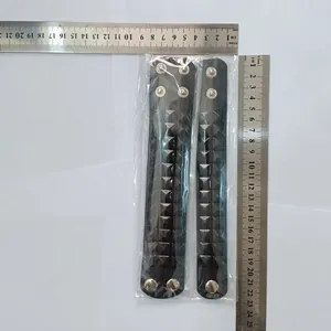 Detailed view of punk black leather bracelets with silver studs and rulers for scale.