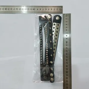 Detailed view of punk leather bracelet with rivets and stars shown next to a steel ruler