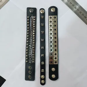 Close-up detail of three punk leather bracelets with metal studs, stars and chains