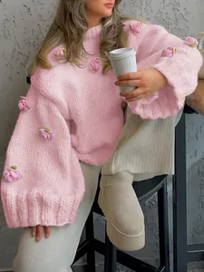 Close-up of pink chunky knit sweater with delicate 3D crochet rose details