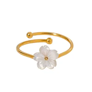 Close-up of elegant 18k gold plated titanium steel ring with white shell cherry blossom