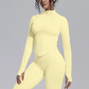 Detailed view of yellow long sleeve yoga jacket with stand-up collar and zipper.