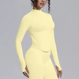 Slim fit yellow long sleeve yoga jacket with high neck, zipper, and thumb holes.