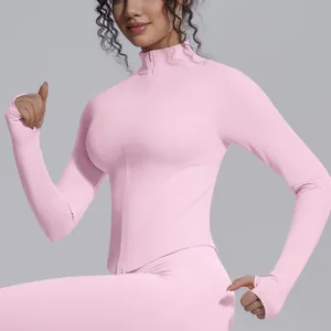 Detail showing the slim fit and high collar of a pink long sleeve zip-up yoga jacket.