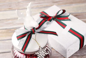 Gros plan de ruban festif à rayures vertes et rouges sur boîte cadeau et couvercle de pot