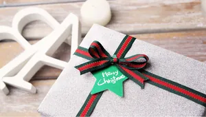 Gros plan d'un coffret cadeau argenté avec ruban rouge et vert et étiquette Noël