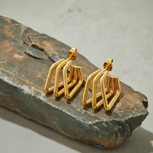 Minimalist gold stainless steel earrings with geometric multi-layer line design on rock.