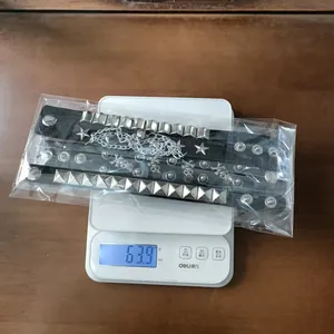 Dettaglio di un set di 3 braccialetti punk rock che mostra un peso totale di 63,9 g sulla bilancia
