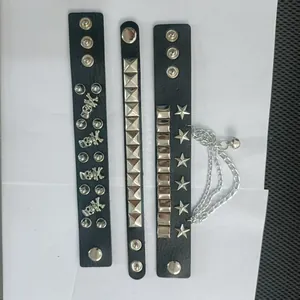 Primo piano di tre bracciali punk in pelle nera con borchie metalliche e teschi