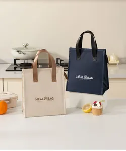 Macro view of beige and navy blue insulated lunch bags with meal bag logo in kitchen
