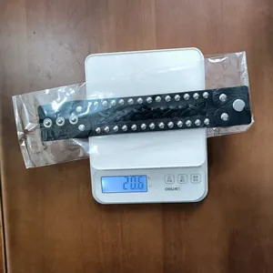 Punk black leather studded bracelet on a scale weighing 20.6g for product detail.