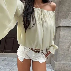 Detail view of off-shoulder lantern sleeve blouse in cream yellow, boho chic style