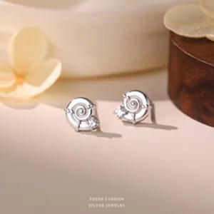 Detailed macro view of S999 sterling silver snail stud earrings with zircon