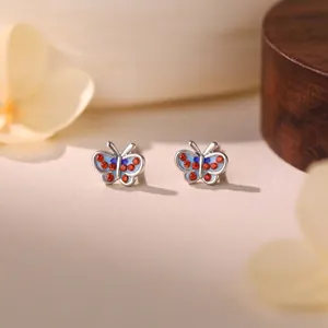 Close-up of mini S999 sterling silver butterfly stud earrings with colorful stones.
