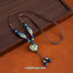 Detailed view of a handmade Jingdezhen ceramic heart necklace with blue glazed beads