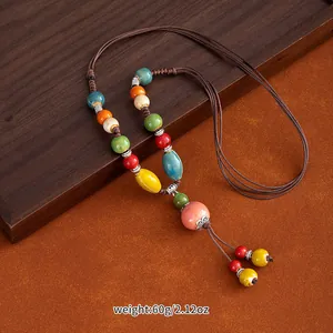 Detailed shot of ethnic ceramic bead sweater chain showing colorful beads and woven cord.