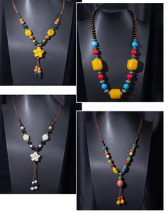 Detailed showcase of four handmade ethnic style ceramic necklaces on black stands