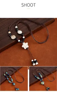 Detail view of handmade ethnic style long ceramic necklaces with braided cord and pendants