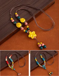 Detail shots of three ethnic-style long ceramic bead necklaces on a wood tray
