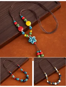 Detail view showing three styles of ethnic ceramic long sweater chains on wood background