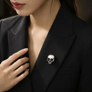 Vintage silver skull brooch pinned to a black blazer lapel, gothic Halloween accessory