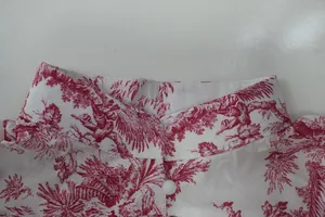 Close-up detail of a white shirt collar featuring an elegant red toile de jouy scenic print