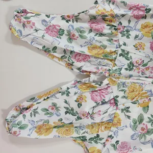 Detail view of a floral print dress featuring a zipper closure and pleated waist design