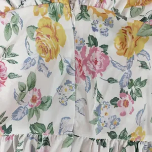 Close-up detail of floral print fabric and invisible zipper on a spring maxi dress