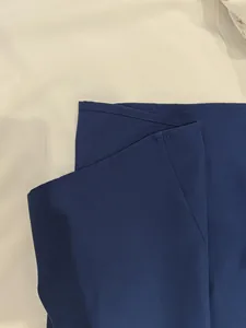 Close-up of elegant navy blue dress showing layered fabric detail and stitching