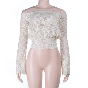 Détail du haut en dentelle beige à épaules dénudées avec manches longues et broderies.