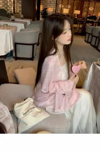 Elegant young woman wearing a pink lightweight summer sun protection shawl in a cafe
