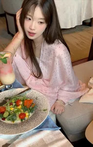 Detailed view of the pink sequined lightweight shawl worn in a restaurant setting