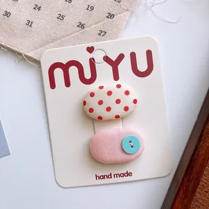 Sweet handmade fabric hair clips set with polka dots and blue button on display card