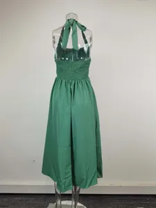 Detailed back view of an elegant green halter neck backless dress with smocked waist