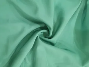Detail view of smooth mint green fabric with elegant soft draped texture