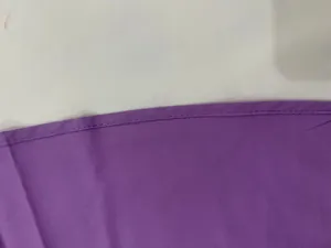 Detailed close-up showing high-quality professional stitching on a purple halter dress