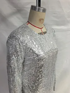 Close-up detail of a sparkling silver sequin long-sleeved bodycon dress on a mannequin